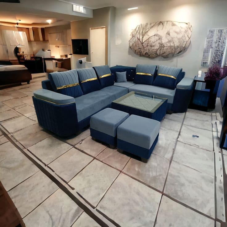 Navy blue U-shaped sectional sofa with gold trim legs in the showroom, kitchen visible behind