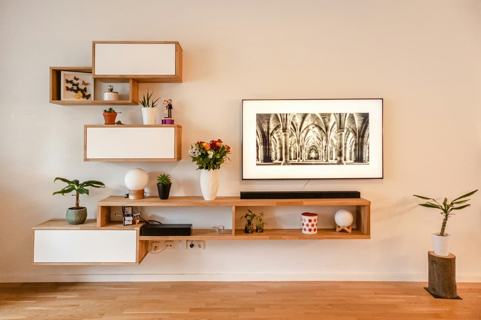 Wall mounted wooden TV unit with floating shelves in a living room