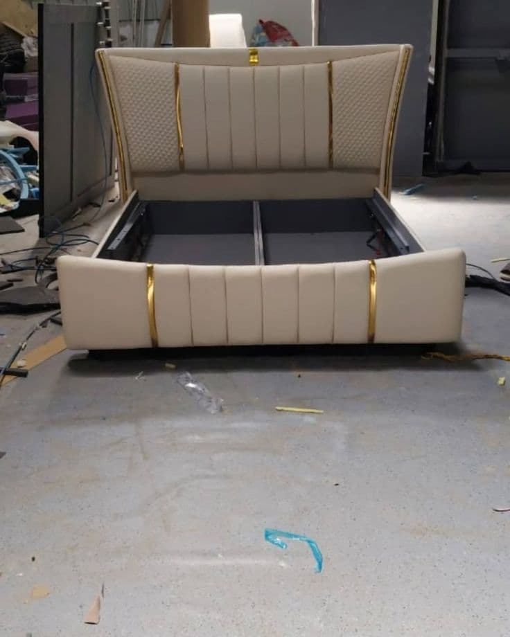 Close up of a cream channel-tufted bed headboard with brass trim