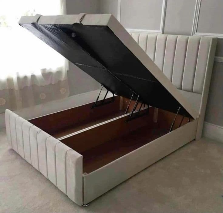Ivory upholstered storage bed with its base lifted open, fresh from the workshop
