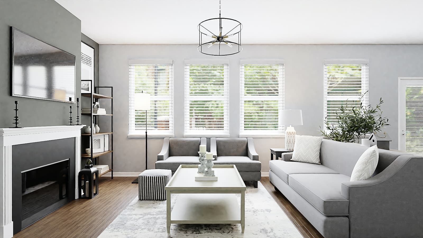 Two grey sofas set at right angles around a white centre table, with a fireplace and shuttered windows