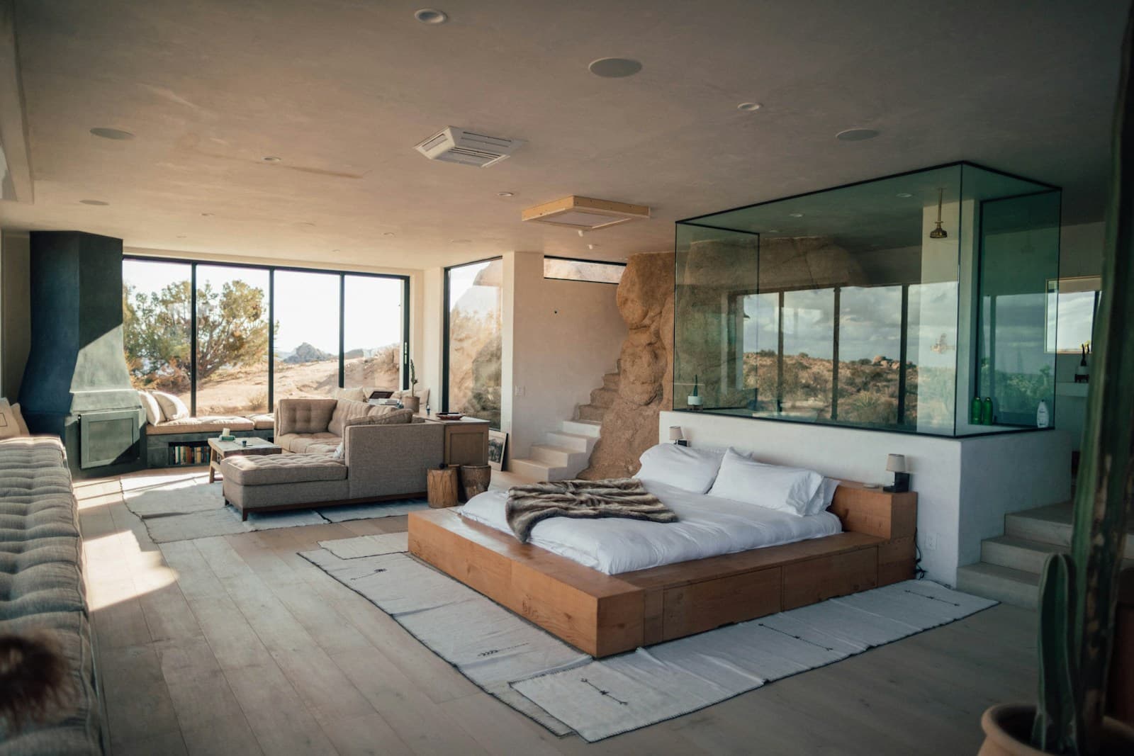 Low wooden platform bed with a wide surround ledge in a minimal bedroom