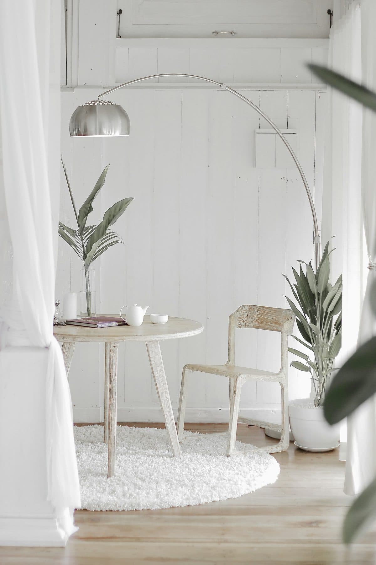 Minimal round dining table and chairs in a bright white room