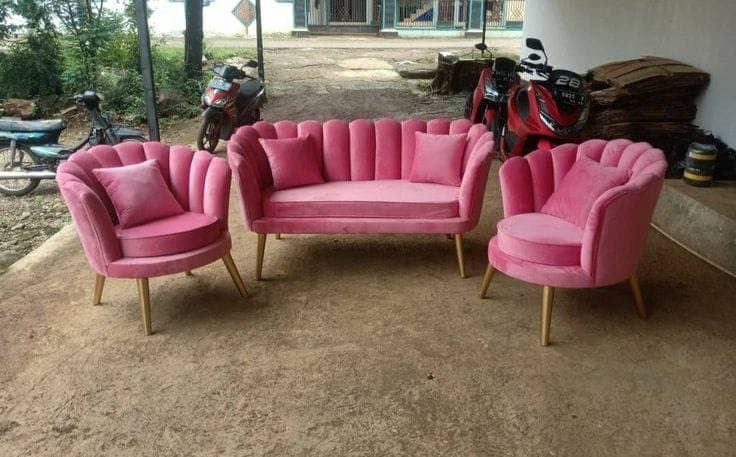 Pink scalloped petal-back accent chairs with a matching loveseat, photographed outside the workshop