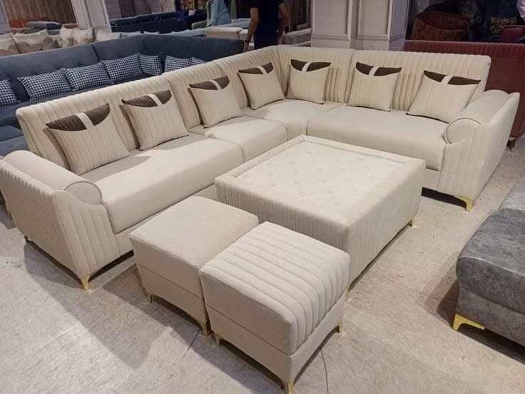 Deep-seated cream U-shaped lounge sectional with matching ottomans in the showroom