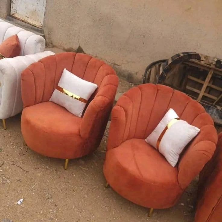 Pair of burnt-orange scalloped petal-back accent chairs, photographed outside the workshop