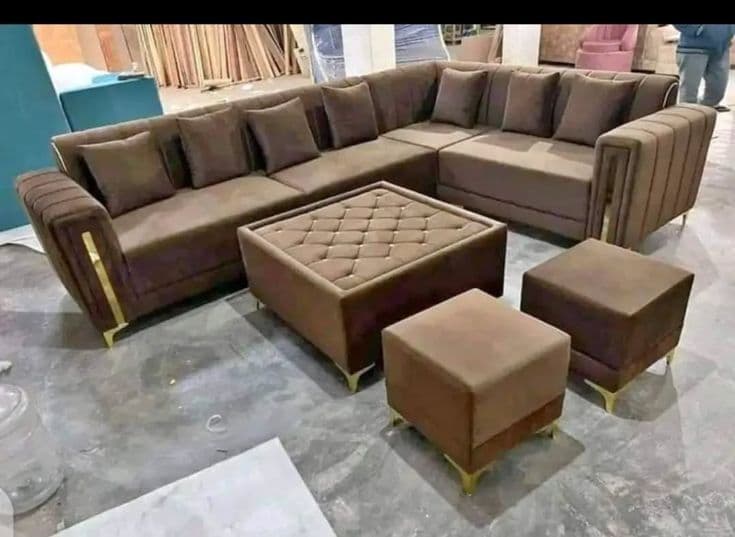 Mocha brown L-shaped sectional sofa staged on the workshop floor, upholstery materials wrapped behind it