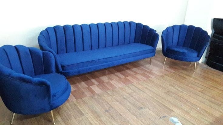 Royal blue scalloped sofa and armchair set on a wooden floor