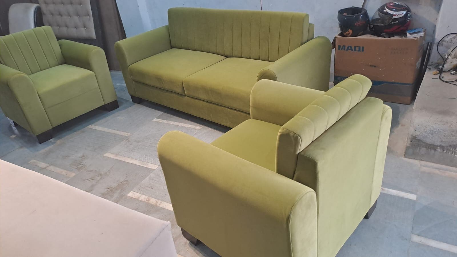 Olive green channel-tufted velvet three-seater sofa with two matching armchairs, photographed in the workshop
